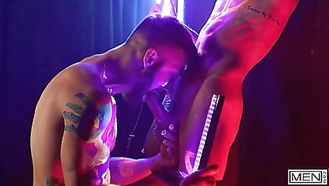 Two naked bodies in the neon light dancing and masturbating